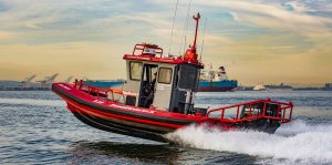 Red and gray Tow Boat U.S. Ambar boat lifted off water