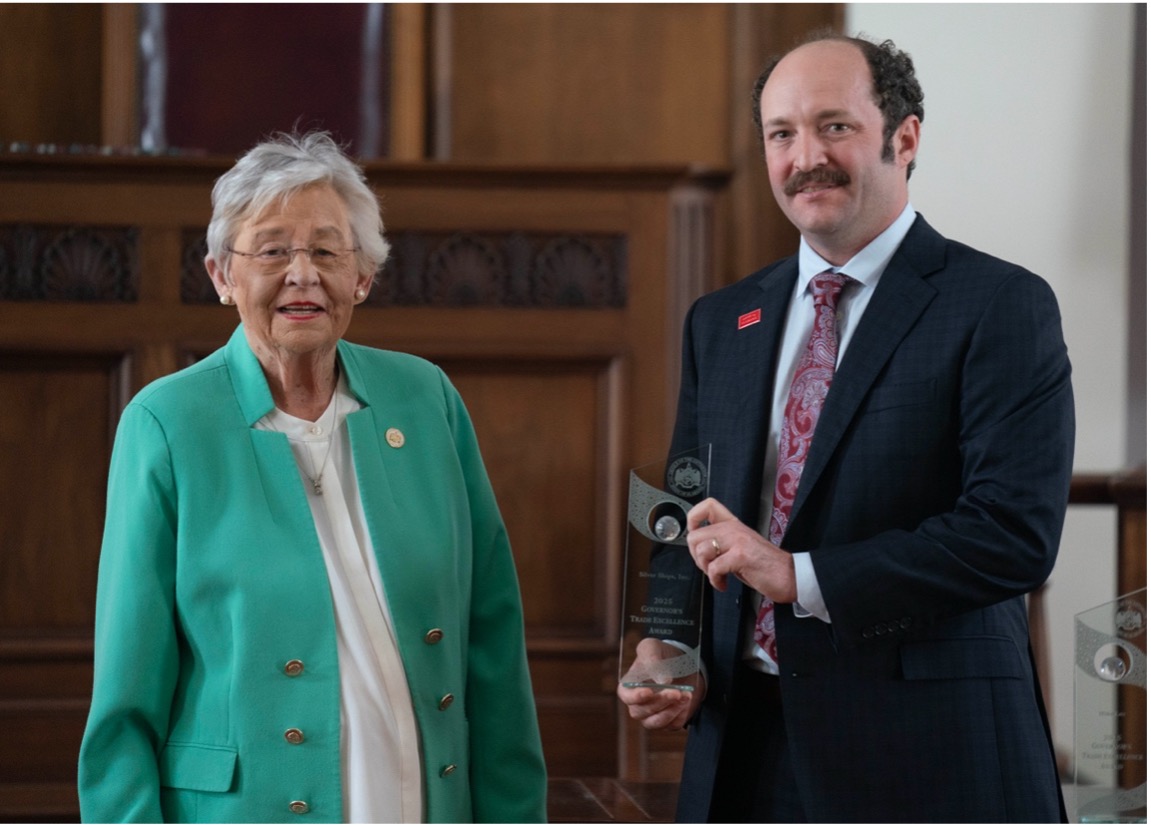 Alabama Governor Kay Ivey (L) and Steven Clarke, CEO of Silver Ships (R) receiving Governor's Excellence Award