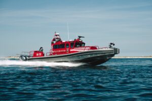 Destin fireboat red vessel speeding through water.